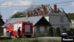 A Polish police officer attends the scene as firefighters work on the destroyed roof of a house on September 10 after Russian drones violated Polish airspace during an attack on Ukraine. Some of the drones were shot down by Poland with backing from its NATO allies. 