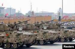 Membri ai Armatei Populare de Eliberare participă cu vehicule blindate la o parada militară. Beijing, 3 septembrie 2025.