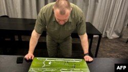 Гэты здымак быў апублікаваны 1 чэрвеня 2025 году Службай бясьпекі Ўкраіны. На ім кіраўнік СБУ Васіль Малюк глядзіць на мапу расейскай вайсковай авіябазы. 