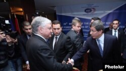 Главы МИД Армении и Турции - Эдвард Налбандян (слева) и Ахмет Давутоглу приветствуют друг друга в отеле «Армения Марриот», Ереван, 12 декабря 2013 г.