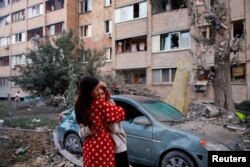 Жени се прегръщат до сграда, ударена от руски дронове и ракети, 28 август 2025 г.