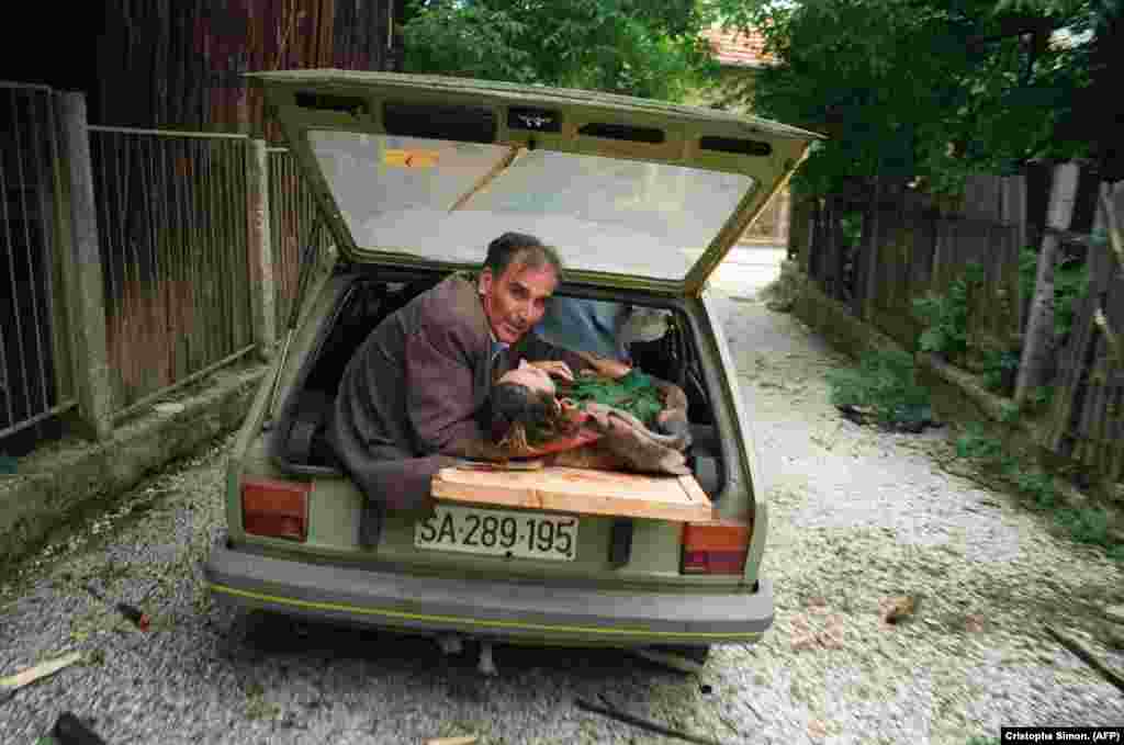 A man cradles the head of a woman badly injured by shelling in Sarajevo on June 27, 1992.&nbsp;