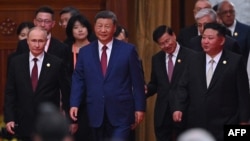 Орусиянын президенти Владимир Путин Кытайдын лидери Си Цзиньпиндин сол жагында, Түндүк Кореянын башчысы Ким Чен Ын сол капталында баратат.