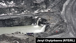 Сүрөттө: карьерге топтолгон сууну насостор менен анын сол тарабындагы аңга тартып чыгарышууда. 