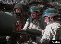 Украински военнослужещи стрелят със самоходна гаубица по руски войски близо до град Покровск, намиращ се на фронтовата линия.