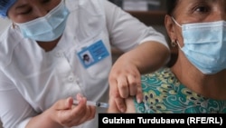 Женщина получает вакцину против COVID-19 в одной из поликлиник Бишкека. Май 2021 года. 