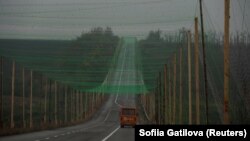 Автоунаа дрондордон коргоо үчүн тор менен жабылган жолдо баратат, Донецк облусунун Славянск шаарына жакын жер, Украина, 27-октябрь, 2025-жыл.