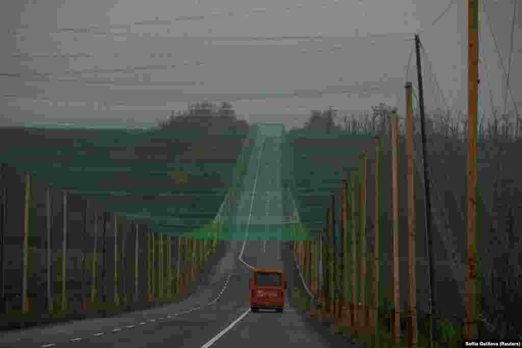 Автомобиль едет по дороге, покрытой антидронной сеткой, недалеко от города Славянск в Донецкой области, Украина, 27 октября 2025 года. REUTERS/Sofiia Gatilova