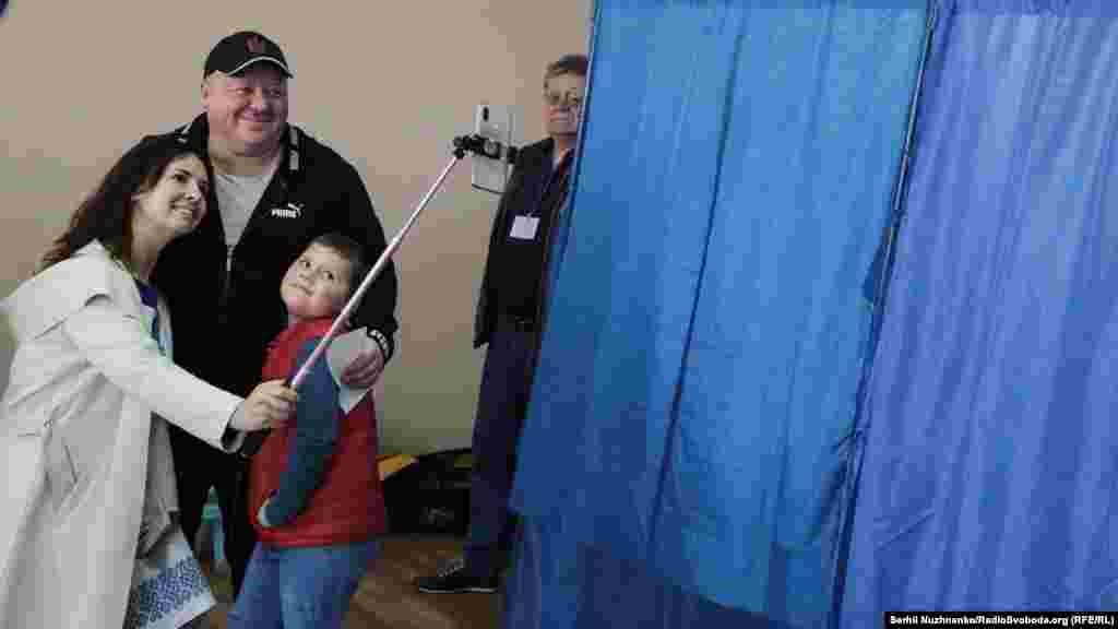 A Ukrainian family takes a souvenir selfie at a polling station in Kyiv on April 21.