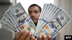 Un angajat arată dolari americani la o casă de schimb valutar din New Delhi, pe 31 iulie 2025.