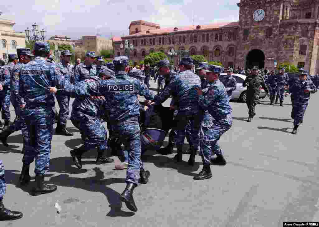A policeman kicks a demonstrator as he is dragged into a police van in Yerevan's Republic Square.