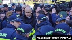 შსს-ის ცნობით, მელია „პოლიციელის შეურაცხყოფისთვის“ დააკავეს. ნიკა მელია პოლიციელების გარემოცვაში. ფოტო არქივიდან. 