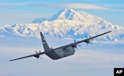 Un avion american C-130J zburând cu muntele Denali (McKinley) în fundal la 19 iulie 2016.