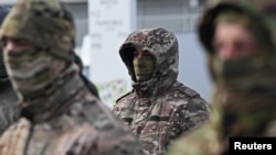 Russian soldiers preparing to deploy to Ukraine attend a ceremony to receive new vehicles in September 2025