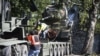 Workers remove a Soviet T-34 tank installed as a monument in Narva, Estonia, on August 16.