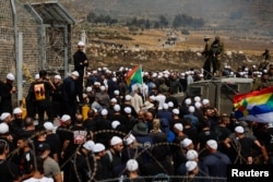 Linia de armistițiu dintre Înălțimile Golan ocupate de Israel și Siria. Druzi israelieni trec granița pentru a-și verifica membrii familiilor din Siria, în mijlocul conflictului continuu din zonele druze din Siria.