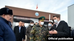 Өкмөт башчынын милдетин аткаруучу Артем Новиков, мамлекеттик салык кызматынын жетекчисинин орун басары Искендер Асылкулов (сүрөттүн сол жагында турат) жана чек ара кызматынын башчысы Уларбек Шаршеев (ортодо формачан турат). “Чалдыбар” өткөрмө жайы. 28-ноябрь, 2020-жыл. 