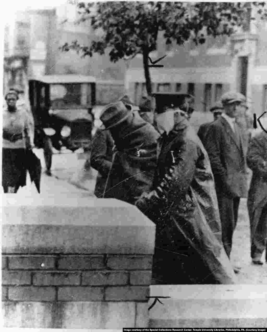 Полицейский сопровождает больного "испанкой" в больницу в Филадельфии в октябре 1918 года.