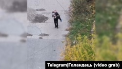 Captură dintr-un videoclip care arată cum un bărbat care în brațe o femeie rănită către soldații ucraineni din Pokrovsk.