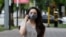 Kazakhstan. A girl in a protective mask is walking along the street of Almaty. June 22, 2020
