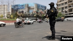A security guard patrols a street in Tehran in the early hours of a cease-fire between Israel and Iran on June 24. Iranian police reported detaining around 21,000 people for alleged security violations during the 12-day war, though the number still in custody is unclear.