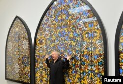 Хърст позира до триптиха си „Врата към царството небесно“ (2007) в галерията „Тейт Модърн“ в Лондон, 2012 г.