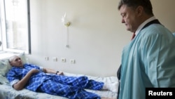 Ukrainian President Petro Poroshenko visits a serviceman who was wounded during the August 31 protest outside parliament. Three National Guardsmen were killed in the violence.