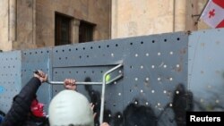 Ցուցարարները փորձում են հեռացնել Վրաստանի խորհրդարանի շենքի մոտ տեղադրված արգելապատնեշը, 14-ը մայիսի, 2024թ.