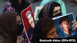 Relatives hold portraits of disappeared family members during a protest in Karachi in August.