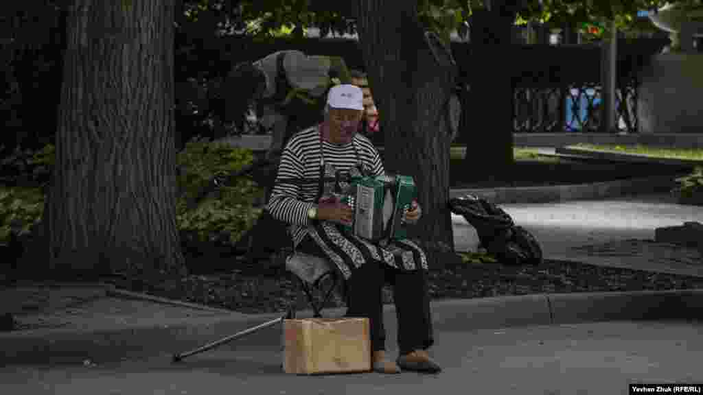 Вуличний музикант з гармошкою