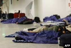 Pasageri dormind pe podea la aeroportul din München în timpul opririi zborurilor din cauza dronelor, la 4 octombrie 2025.