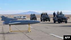 Iranian military officials inspect drones on display prior to a drill at an undisclosed location in central Iran in January 2021.