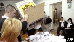 Members of a local election commission empty a ballot box in Chisinau on April 5