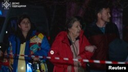 Oameni scoși în stradă la Odesa de un atac rusesc cu dronă, în primele ore ale zilei de joi, 4 decembrie 2025. 