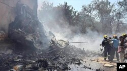 Pompierii lucrează la locul prăbușirii unui avion în orașul Ahmedabad din nord-vestul Indiei, în statul Gujarat, joi, 12 iunie 2025.