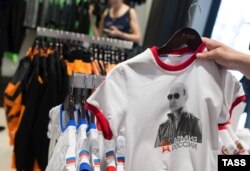 Russiýanyň prezidenti Wladimir Putiniň şekili basylan futbolka Moskwanyň söwda dükanynda.
