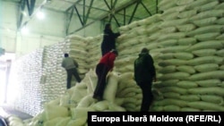 Angajați lucrând într-un depozit de zahăr din Republica Moldova (imagine de arhivă).
