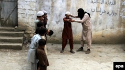 An unidentified militant of Islamic State (IS) imparting light weapons training to children at an undisclosed location in the Kunar province, eastern Afghanistan in July.