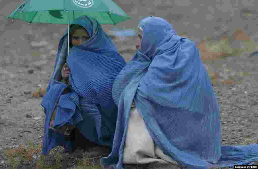 Из продовольственной очереди не уходят и во время дождя. 