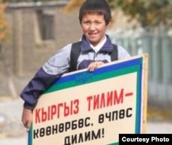 Elinde gyrgyz diliniň gymmatlyklary barasynda şygar göterip duran bir oglanjyk. Illýustratiw surat.