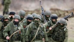 Російські військовослужбовці у формі без розпізнавальних знаків марширують біля української військової частини в Перевальному, 5 березня 2014 року