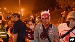 Minskde polisiýa bilen demonstrantçylaryň arasynda bolan çaknyşyklardan soň adamlar ýaralylara kömek edýär. 10-njy awgust, 2020 ý.