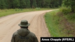 Un polițist de frontieră estonian și un soldat rus în zona „Cizmei Saatse” de la granița comună a celor două țări.