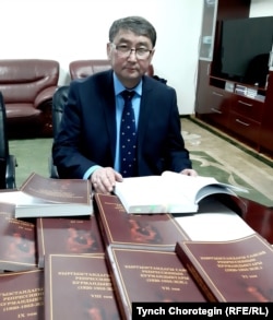 Профессор Төлөбек Абдырахманов «Кыргызстандагы саясий репрессиянын курмандыктары: (1920–1953-жылдар)” деген он томдуктун мукабаларын көрсөтүүдө.