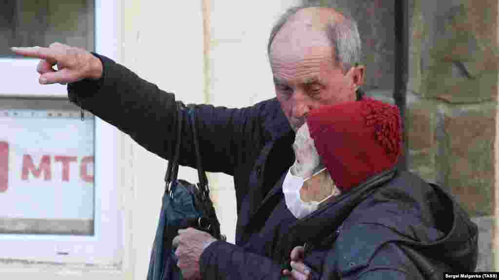 Люди похилого віку на одній з вулиць Судака. З 25 жовтня кримчан старше 65 років зобов'язали не виходити з дому до особливого розпорядження. Виняток зробили для тих, чиєму життю та здоров'ю є пряма загроза, чия присутність на робочому місці &laquo;обумовлена забезпеченням безперервних технологічних та інших процесів, необхідних для функціонування організацій і установ&raquo;, а також медиків, соцпрацівників, співробітників Роспотребнадзору та Центру гігієни і епідеміології в Криму і Севастополі. Також обмеження не торкнуться осіб, залучених до російського перепису населення і вакцинованих