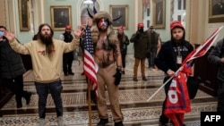 O imagine neverosimilă: mai mulți susținători de-ai lui Donald Trump s-au pozat în Capitoliu după ce au reușit să ia cu asalt clădirea.