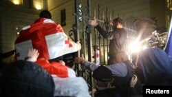 Suporterii opoziției, încercând să pătrundă în curtea palatului prezidențial de la Tbilisi, pe 4 octombrie 2025