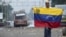 Venezuela - A demonstrator holds a Venezuelan flag on the Francisco de Paula Santander international bridge in Urena, Venezuela, border with Colombia on February 24, 2019, following protests in the region after Venezuelan President Nicolas Maduro ordered 