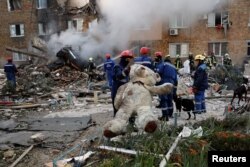 Спасител държи плюшена играчка на мястото на жилищен блок, ударен от руска ракета и дронове по време на атаката над украинската столица Киев, 28 август 2025 г.
