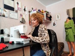 მარიამ ცხოვრებაშვილი ტყიბულში, თავის სამკერვალოში ფერად პირბადეეს კერავს